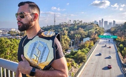 Ozzy Diaz holds his former LFA belt atop a bridge over the highway in Los Angeles, CA
