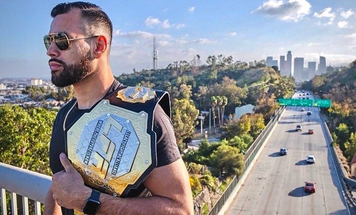 Ozzy Diaz holds his former LFA belt atop a bridge over the highway in Los Angeles, CA