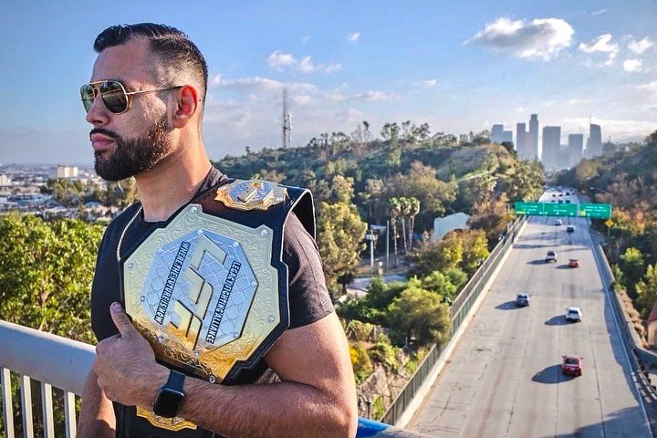 Ozzy Diaz holds his former LFA belt atop a bridge over the highway in Los Angeles, CA