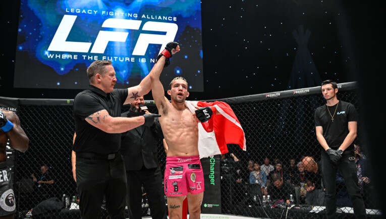 Lozej get's his hand raised at LFA 193 with the Canadian flag wrapped around his shoulders
